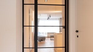 Ein modernes Interieur mit einer Schiebetür zu einem Schlafzimmer und einer Küchenzeile.