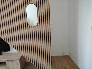 A room with a wooden slat wall, a white door, and a wooden floor. - Townhouse with a courtyard in Cosne-sur-Loire (COSNE-COURS-SUR-LOIRE)