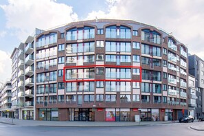 A multi-story building with a curved facade, large windows, and balconies. - Apartment in Ostend With Marina Views (Ostend)
