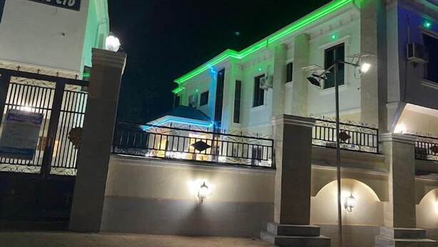 A hotel with a gated entrance, a covered outdoor area, and a well-lit facade. - De Vegas Hotel (Nnewi)
