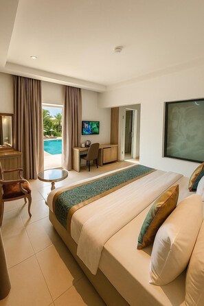 A hotel room with a large bed, a desk, a chair, a TV, and a view of a swimming pool. - Maxbe Continental Hotel (Awka)