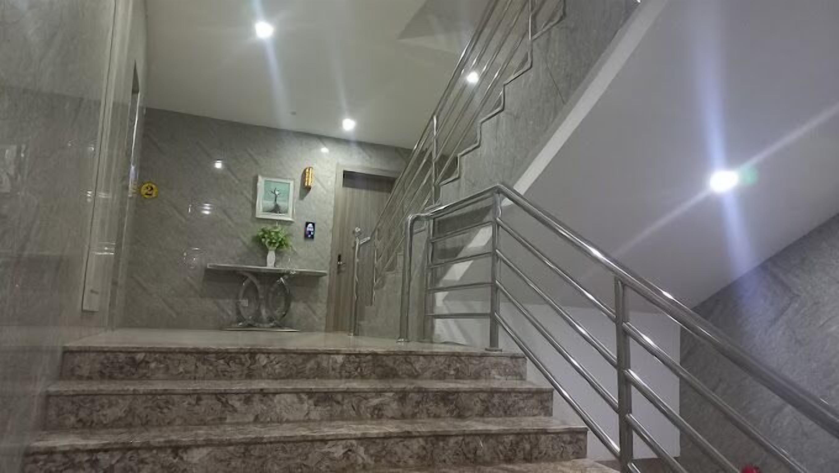 Eine Marmortreppe mit Metallgeländern, die zu einer oberen Etage führt.