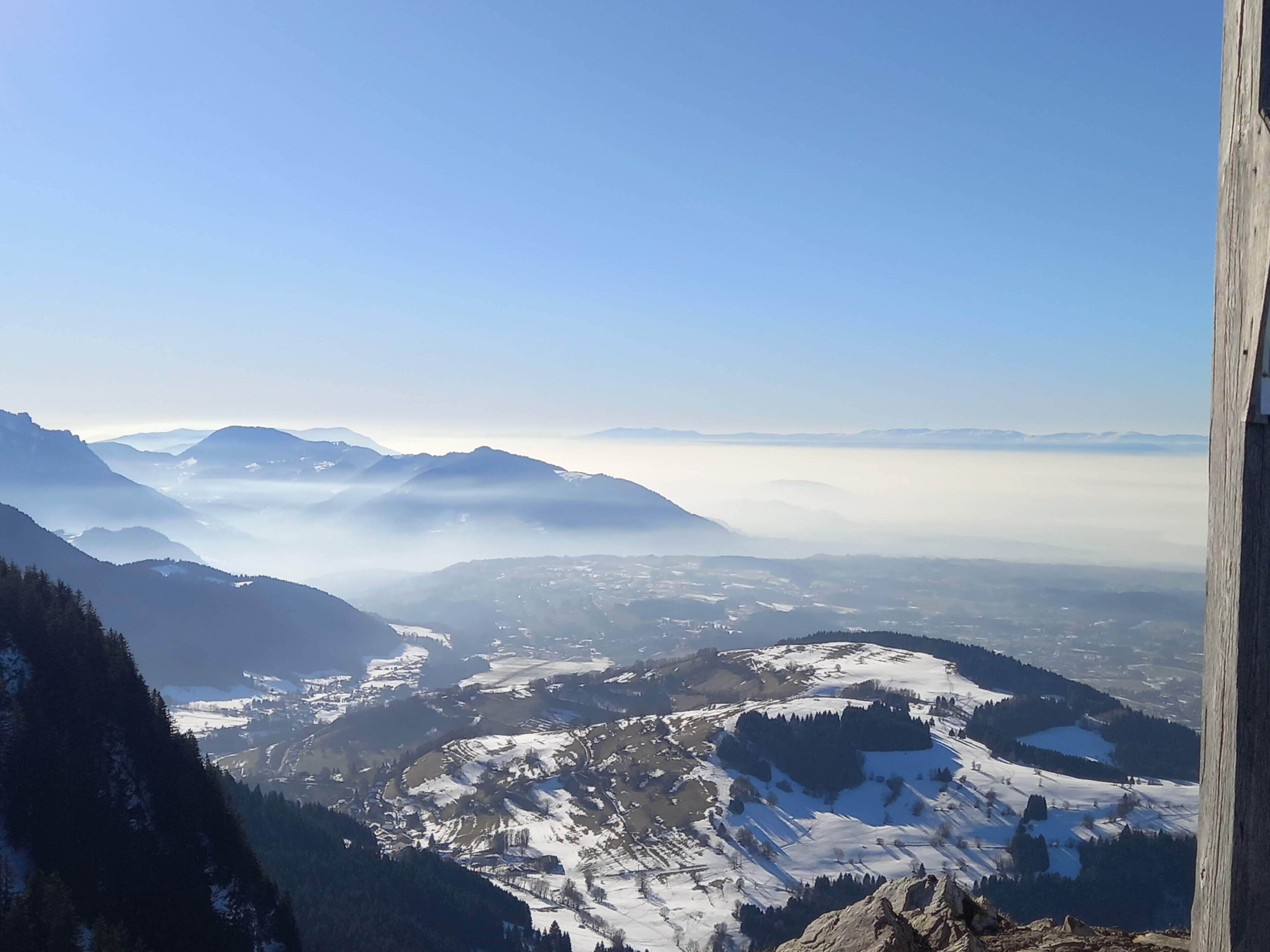 Una vista panoramica di un paesaggio montuoso con cime e valli innevate.