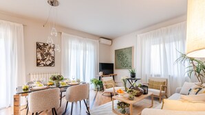 A modern living room with a dining area, featuring a wooden coffee table, comfortable seating, and artwork on the walls. - The City Terrace Apartment: smart 2 bedrooms in Lucca (Lucca)