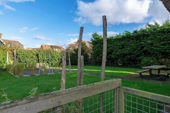 A fenced garden with a picnic table, a pond, and a wooden fence. - De Buitenplaats 134 Villa With Enclosed Garden (Callantsoog)