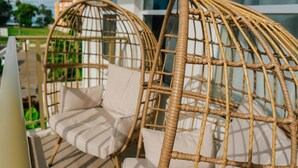 Wicker chairs with cushions on an outdoor deck.