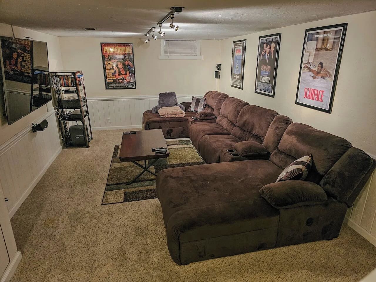 A living room with a sectional sofa, a coffee table, and a TV stand.