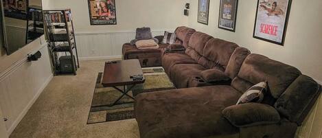 A living room with a sectional sofa, a coffee table, and a TV stand.