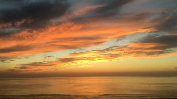 A sunset over a calm sea with a clear horizon. - Apartment in Ostend Near the Beach (Ostend)