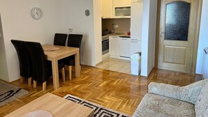 A modern apartment with a dining area, kitchen, and living room. - Air Urban 4-room apartment, balcony, parking, air-conditioned and fully equipped (Sarajevo)