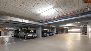 Eine mehrgeschossige Parkgarage mit Betonböden und -decken, einschließlich mehrerer geparkter Autos und sichtbarer Stützsäulen.
