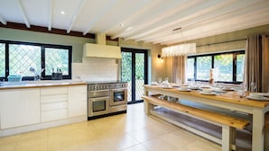 A modern kitchen with a central island, built-in oven, and large windows. - Spacious East Sussex retreat with tennis court, hot tub, and room for 24 (Whitesmith)