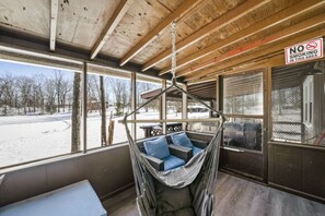 A cozy room with a hammock chair, large windows, and a 'No Smoking' sign.