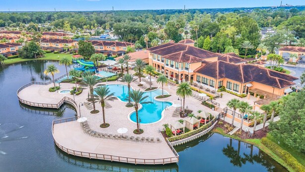 A resort with multiple swimming pools, a water park, and a large building with a red-tiled roof.