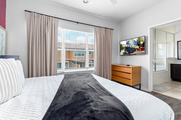A hotel room with a bed, a wooden dresser, a television, and a window with curtains. - Pool~Waterslides~Games Room~Old Town~Disney~& More (Kissimmee)