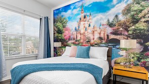 Ein Schlafzimmer mit einem großen Bett, einem Nachttisch, einer Lampe und einem Wandgemälde eines Schlosses.