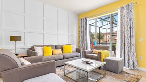 A modern living room with a sectional sofa, a coffee table, and a view through a large window.