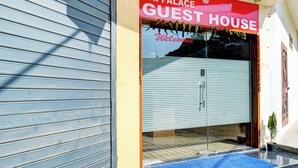 A hotel entrance with a closed shutter, a sign reading "Hotel Jai Palace Guest House," and a welcome message. - Hotel Jai Palace & Guest House (Jaipur)