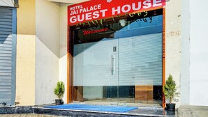 A hotel entrance with a red sign reading "Hotel Jai Palace Guest House" and a blue mat at the entrance. - Hotel Jai Palace & Guest House (Jaipur)
