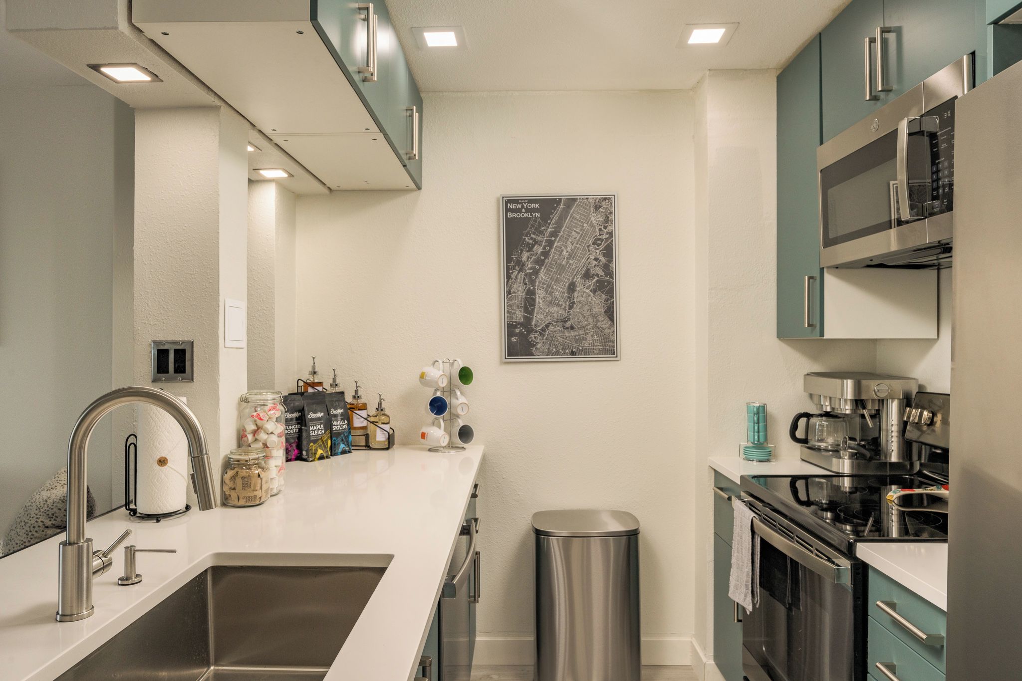 Una cucina moderna con elettrodomestici in acciaio inossidabile, un lavello e un cestino.