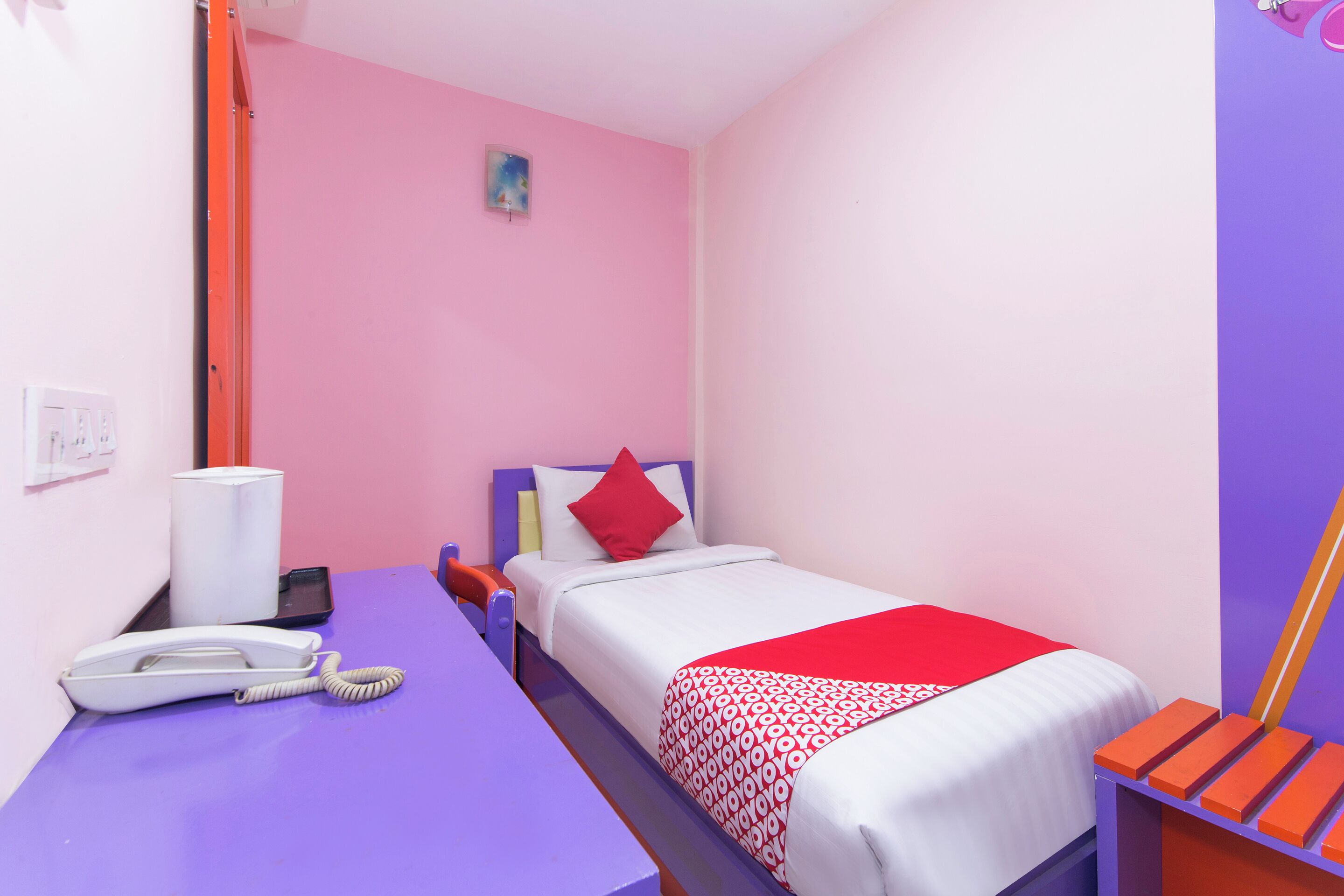 Ein Zimmer mit einem Bett, einem Schreibtisch mit Telefon und einem Sessel.
