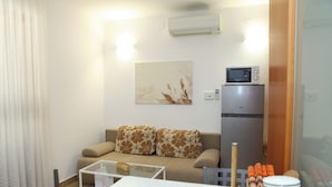 A modern living room with a sofa, a coffee table, a microwave, and a refrigerator. - Apartments Vallis Rabiosa  (Zadar)
