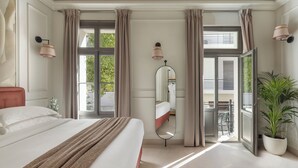 A hotel room with a bed, a large mirror, a potted plant, and a view of the outside. - Airy Suites Athens (Athens)