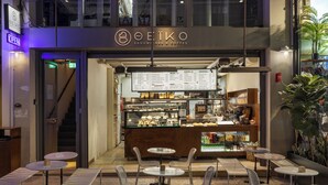 A café with outdoor seating, a menu board, and a staircase leading to an upper level. - Airy Suites Athens (Athens)