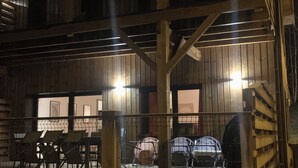 Ein zweistöckiges Holzhaus mit Balkon und einem eingezäunten Parkplatz.