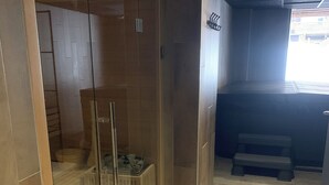 Ein modernes Badezimmer mit Duschkabine aus Glas, einer Sitzbank und Fliesenboden.