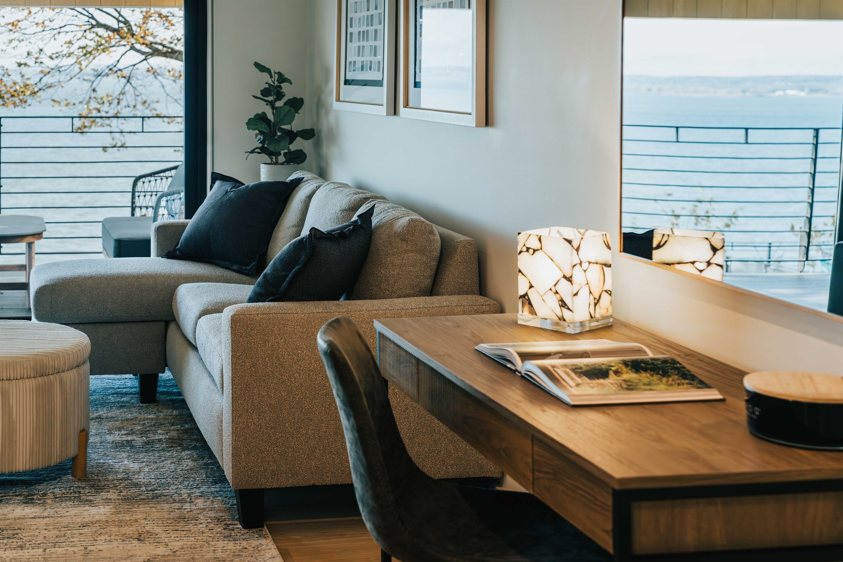 Un salon moderne avec un canapé, une table en bois et une vue sur la mer.