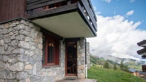 A stone building with a wooden deck and a door leading to an interior. - Floor -2, view mountain, terrace, ski locker, 30m², Valmorel (Valmorel)
