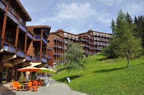 A hotel with multiple balconies, outdoor seating, and a sign for a pizza place. - 300m from resort center, Ground floor, balcony, tv, 28m², Les Arcs (Les Arcs)