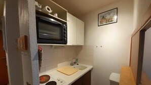 A compact kitchen with a built-in oven, a sink, and a small countertop. - 70m from ski slopes, 2nd floor, balcony, tv, ski locker, 19m², Valfréjus (Valfréjus)