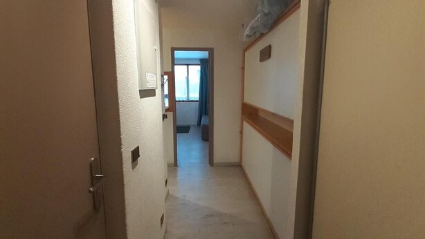 A narrow hallway with a door on the left and a window at the end. - 70m from ski slopes, 2nd floor, balcony, tv, ski locker, 19m², Valfréjus (Valfréjus)