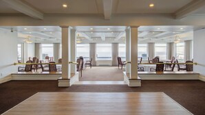 A spacious hotel lobby with a high ceiling, large windows, and a central seating area with chairs and tables. - La Pinsonnière (La Malbaie)