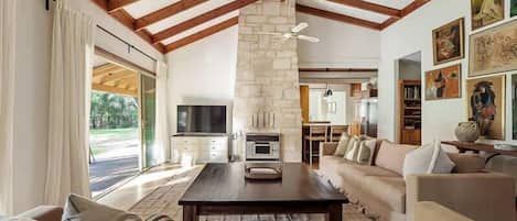 A spacious living room with a fireplace, a sofa, and a television.