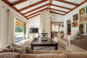 Una sala de estar amplia con chimenea, un sofá y una televisión.