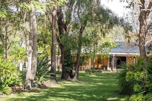 A house surrounded by tall trees and a well-maintained lawn.