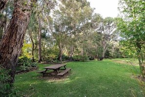 A picnic table in a grassy area surrounded by trees.