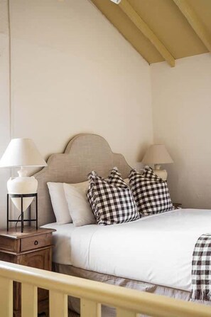 A bedroom with a bed, two bedside tables, a lamp on each table, and checkered pillows. - Orchard Homestead—A True Rural Wellness Escape (Yallingup Siding)
