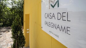 Une enseigne sur un mur jaune, portant les inscriptions « CASA DEL FALEGNAME » et « AFFITTACAMERE ».