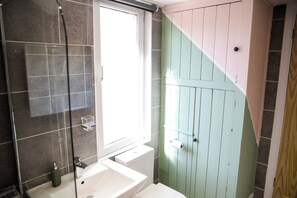 Un baño con ducha, lavabo e inodoro.