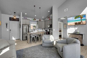 A modern kitchen with a central island, bar stools, and pendant lighting. - Rose Canyon Lake Cabin at Mt. Lemmon Hotel Overlooking Summerhaven, Arizona (Mount Lemmon)