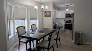 A dining area with a dark wooden table, six chairs, and a chandelier. - Beautiful 3/2 Home, quiet location, close proximity to Texas A&M University (Bryan)