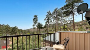 A balcony with a table and chairs, a satellite dish, and a view of trees and hills. - Ski Tucson Cabin at Mt Lemmon Hotel Overlooking Summerhaven, Arizona (Mount Lemmon)