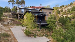 A modern two-story house with a covered porch, a paved driveway, and a hillside setting. - Ski Tucson Cabin at Mt Lemmon Hotel Overlooking Summerhaven, Arizona (Mount Lemmon)