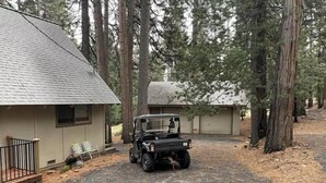 A vehicle parked in a driveway with a house and a covered structure in a forested area. - GREAT FAMILY LOCATION!  Peace in the Trees N Mace (Pioneer)