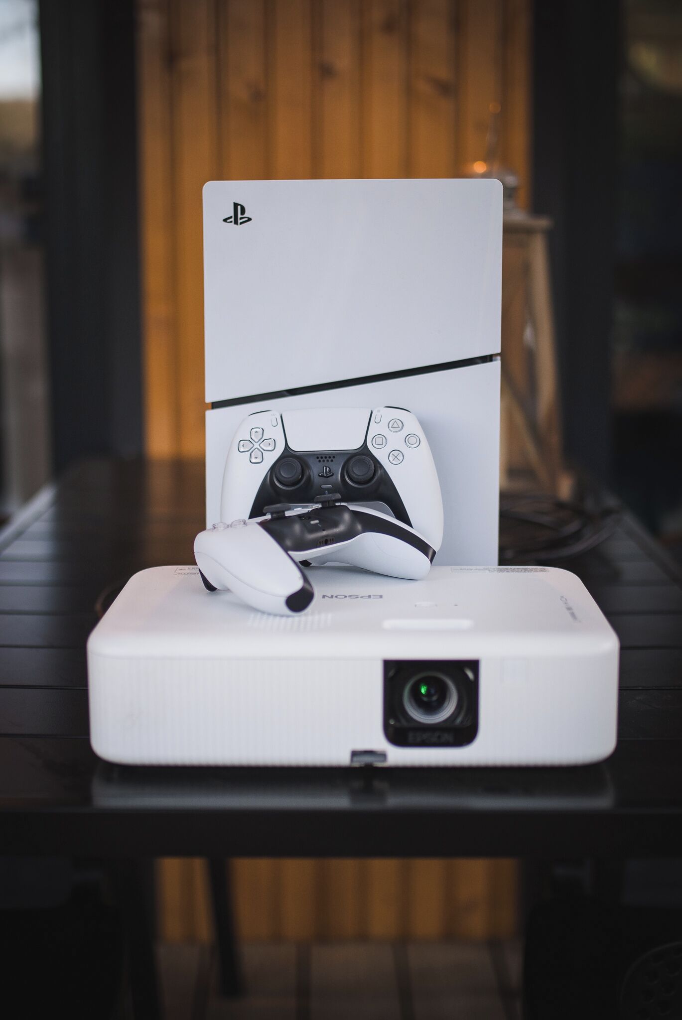 Um console PlayStation 5 sobre um suporte branco com um controle de jogo.
