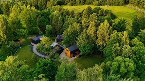 An aerial view of a residential area with multiple houses surrounded by dense forest. - Stare Sady Kopytówka (Brzeznica)